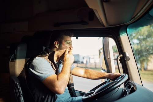 A truck driver yawning, representing the common causes of truck accidents